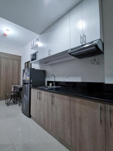 uma cozinha com um lavatório e um frigorífico em Field Residences Bldg5 em Manila