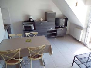 een keuken met een tafel met stoelen en een magnetron bij Appartement Carnac, 4 pièces, 6 personnes - FR-1-477-145 in Carnac