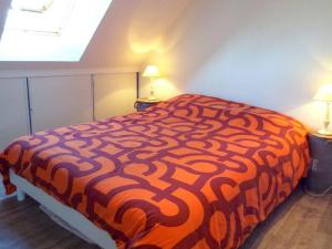 ein orangefarbenes und weißes Bett in einem Zimmer mit 2 Lampen in der Unterkunft Appartement Carnac, 4 pièces, 6 personnes - FR-1-477-145 in Carnac