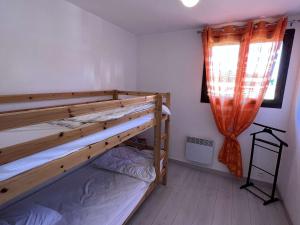 a bedroom with two bunk beds and a window at Maison Vendres, 5 pièces, 10 personnes - FR-1-701-15 in Vendres