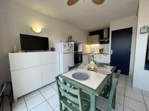 kuchnia ze stołem, krzesłami i lodówką w obiekcie Pavillon avec Terrasse, Piscine et BBQ - 600m Plage, 4 Pers - FR-1-701-41 w mieście Vendres