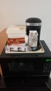 a coffee maker sitting on top of a microwave at OSU King Bed Hotel Room 103 Booking in Stillwater