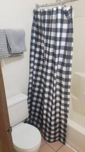 a bathroom with a black and white shower curtain at OSU King Bed Hotel Room 103 Booking in Stillwater +4 photos