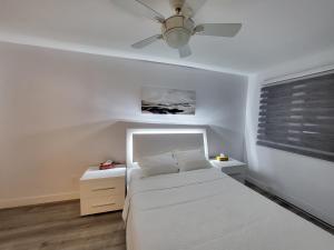 a bedroom with a white bed and a ceiling fan at 4 Bedrooms Beautiful Townhouse in Montréal