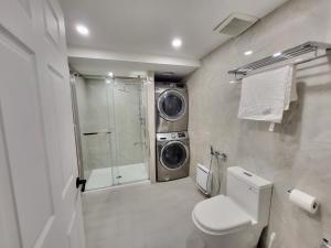 a bathroom with a toilet and a washing machine at 4 Bedrooms Beautiful Townhouse in Montréal
