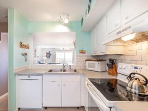 a kitchen with white cabinets and a sink at Tybee Lights 110C in Tybee Island