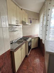 a kitchen with a sink and a stove top oven at Apartament Onesti in Onești +6 photos