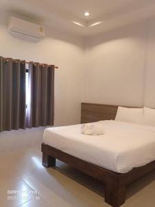 1 dormitorio con cama y ventana en Mac's Bay Resort, en Baan Tai