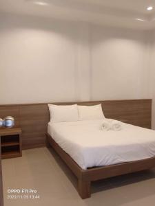 a bed with two towels on it in a room at Mac's Bay Resort in Baan Tai