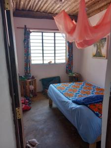 1 dormitorio con cama y ventana en Bibi Mrembo Guesthouse, en Pingwe