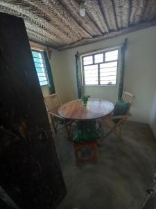 a room with a table and chairs and a window at Bibi Mrembo Guesthouse in Pingwe