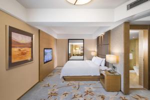 深セン市にあるThe LA Hotel 新世界伟瑞酒店のベッドとバスルーム付きのホテルルームです。