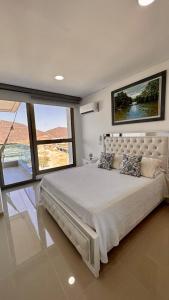 a bedroom with a large bed and a large window at Adela Suite in Santa Marta