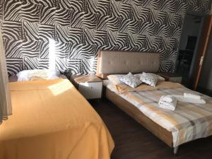 AtakumにあるGüzel Yalı Evleri Residence &Apart Hotelの黒と白の壁紙を用いたベッドルーム1室(ベッド2台付)