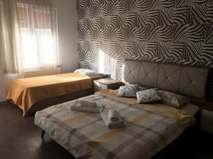 a bedroom with two beds and a patterned wall at Güzel Yalı Evleri Residence &Apart Hotel in Atakum