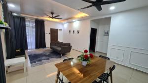 チャンルーンにあるD'Lisha Homestay Changlun/Bukit Kayu Hitam/Sintokのリビングルーム(木製テーブル、椅子付)