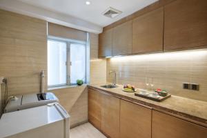 a kitchen with wooden cabinets and a sink at The LA Hotel 新世界伟瑞酒店 in Shenzhen