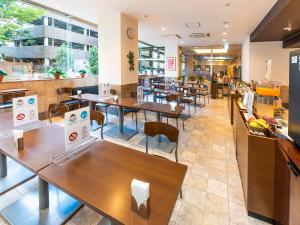 a restaurant with tables and chairs in a cafeteria at Hotel Mark-1 Tsukuba in Tsukuba