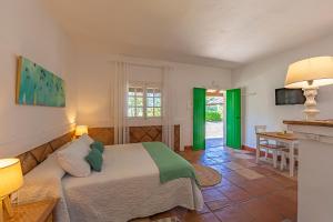 1 dormitorio con 1 cama y sala de estar en Hotel-Apart CORTIJO LAS PIÑAS en Tarifa