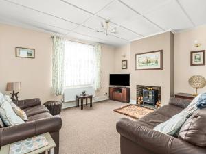Sala de estar con 2 sofás y TV en Cosy Cottage, en Lyndhurst