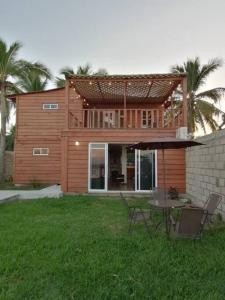 a house with a table and chairs in the yard at Cabaña Villa Sol in Tonalá