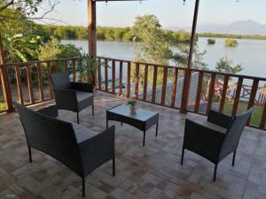 a patio with chairs and a table with a view of a river at Cabaña Villa Sol in Tonalá