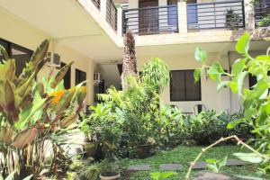 a garden in front of a house with plants at Balaibinda Lodge in Coron