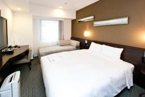 Postel nebo postele na pokoji v ubytování Sotetsu Fresa Inn Yokohama Sakuragi-cho