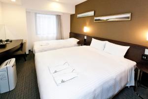 Postel nebo postele na pokoji v ubytování Sotetsu Fresa Inn Yokohama Sakuragi-cho