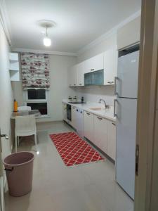 a kitchen with white appliances and a red rug at اسطنبول اسنيورت ستار تاورز in Esenyurt