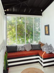 asiento junto a la ventana con almohadas en HARBOUR VIEW FUNKY AND ECLECTIC TWO BEDROOM HOME en Mossel Bay