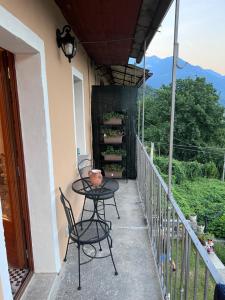 un patio con 2 sedie e un tavolo sul balcone di Appartamento completamente ristrutturato a Montecrestese