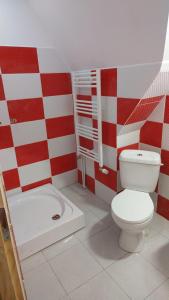 a bathroom with a white toilet and a red and white wall at Camping Aviator Busteni, camere in Buşteni