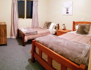 Cette chambre comprend 2 lits et une fenêtre. dans l'établissement Tealuca Holiday Home, à Ngataki