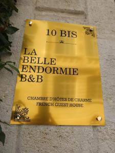 La Belle Endormie B&B French Guest house في بوردو: علامة صفراء على جانب المبنى