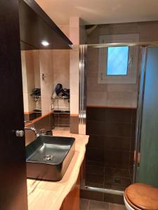 ein Bad mit einem Waschbecken, einem WC und einem Fenster in der Unterkunft House with Garden in Saronis in Saronida