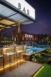 a bar with chairs and a swimming pool at night at Hyatt Place Kathmandu in Kathmandu