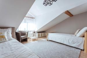 sypialnia na poddaszu z 2 łóżkami i krzesłem w obiekcie Włostowicka Ostoja w mieście Puławy