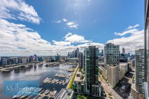 Melbourne Private Apartments - Collins Wharf Waterfront, Docklands في ملبورن: اطلالة على مدينة بها نهر ومباني