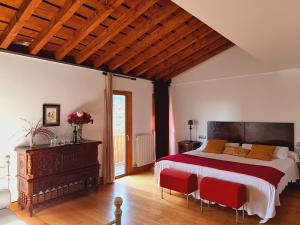 1 dormitorio con 1 cama grande y sillas rojas en Posada Los Calderones, en Santillana del Mar
