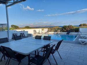 a patio with a table and chairs and a swimming pool at Hestia in Kos