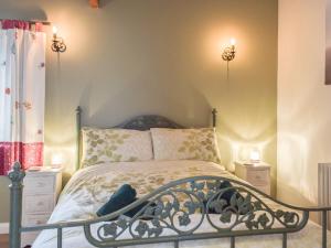 a bedroom with a bed and two night stands at Pipistrelle Cottage - Uk34447 in Mathry