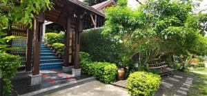 een huis met trappen en een bank en bomen bij Aha Lanta Cozy Hostel in Koh Lanta