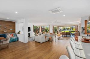 sala de estar con muebles blancos y mesa en Broadbeach Bungalow - Heated Pool - Sleeps 7, en Gold Coast