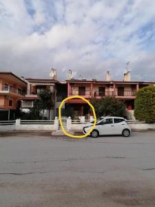 a white car parked in front of a building at Aristotelis Apartment in Nikiti +2 photos
