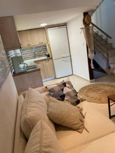 a living room with a couch with pillows and a kitchen at Aristotelis Apartment in Nikiti