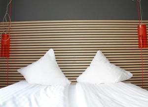 a bed with white sheets and two pillows at Annex Copenhagen in Copenhagen