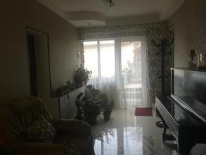a living room with a couch and a large window at House 125a in Dilijan