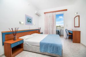 um quarto com uma cama, uma mesa e uma janela em Ano Kampos Hotel em Faliraki