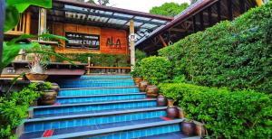 een set blauwe trappen met planten voor een gebouw bij Aha Lanta Cozy Hostel in Koh Lanta